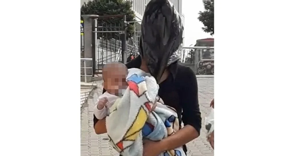 Kucağında bebek kafasında poşet!