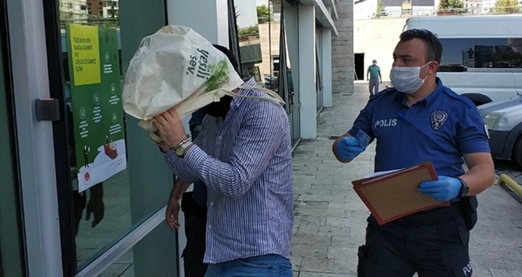 AVM'den hırsızlık zanlısı, adliyeye çıkarılırken tanınmamak için kafasına bez çanta geçirdi