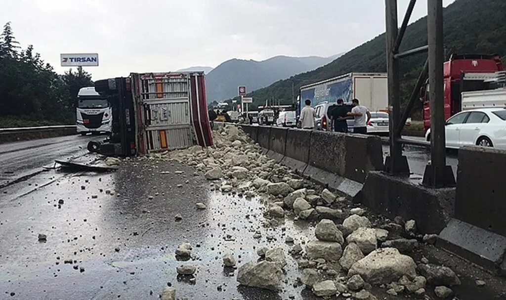 Hafriyat kamyonu devrildi, dolgu malzemeleri yola saçıldı