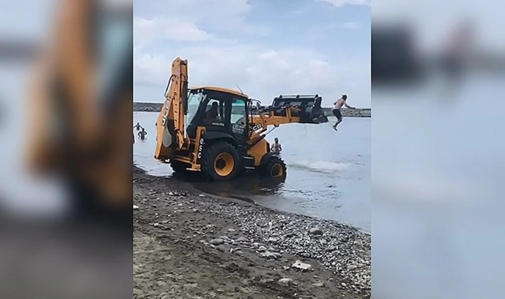 İş makinesini sahile getirip kepçesinden denize atladılar