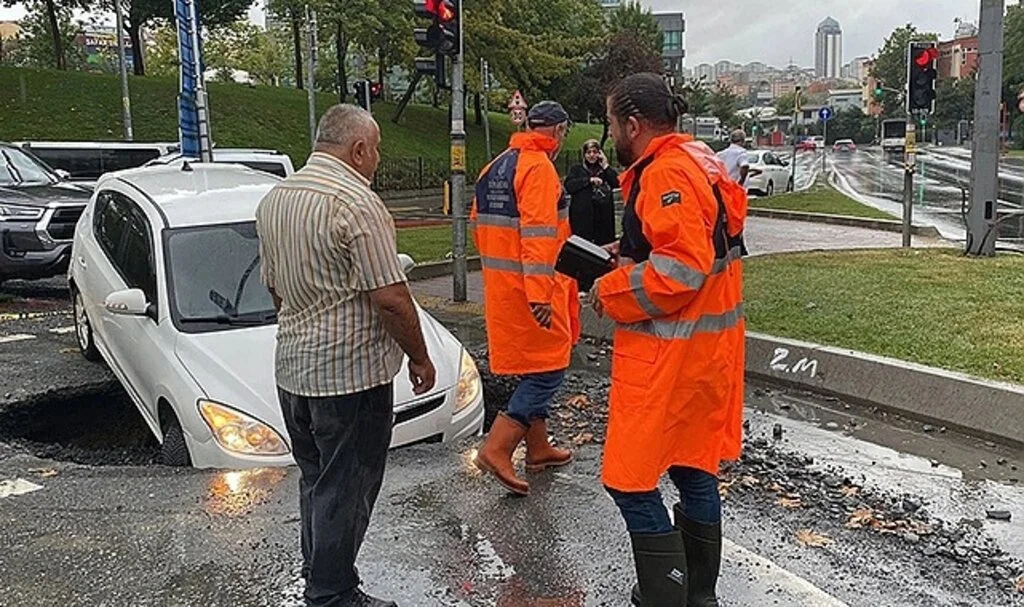 İstanbul'da tomobil yağmur nedeniyle çöken yola düştü
