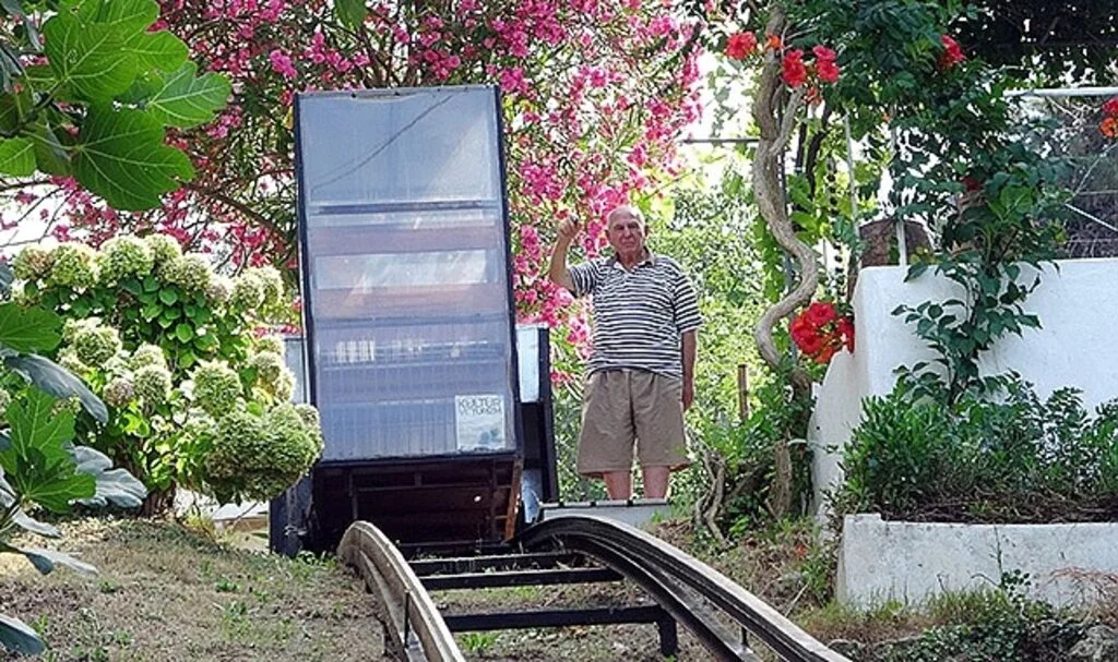 Yokuşun başındaki evine kurduğu raylı sistemle gidiyor