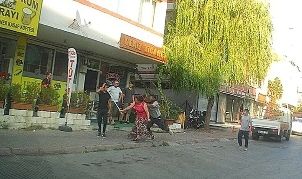 Eli sopalı kadın önüne gelen erkeği dövdü