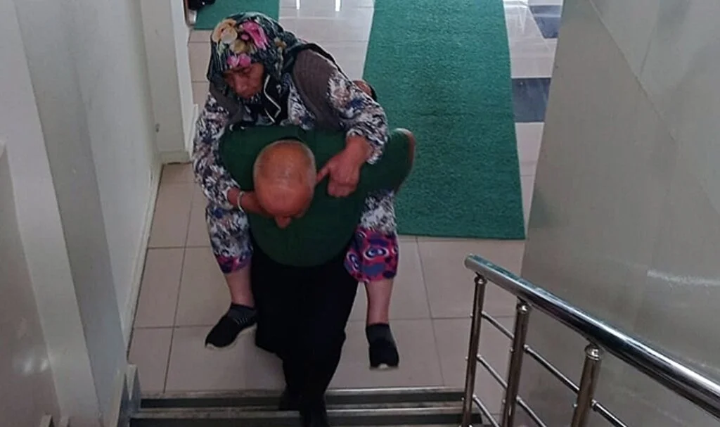 Nüfus müdürlüğü memuru, yaşlı kadını 1. kattaki müdürlük ofisine sırtında taşıdı