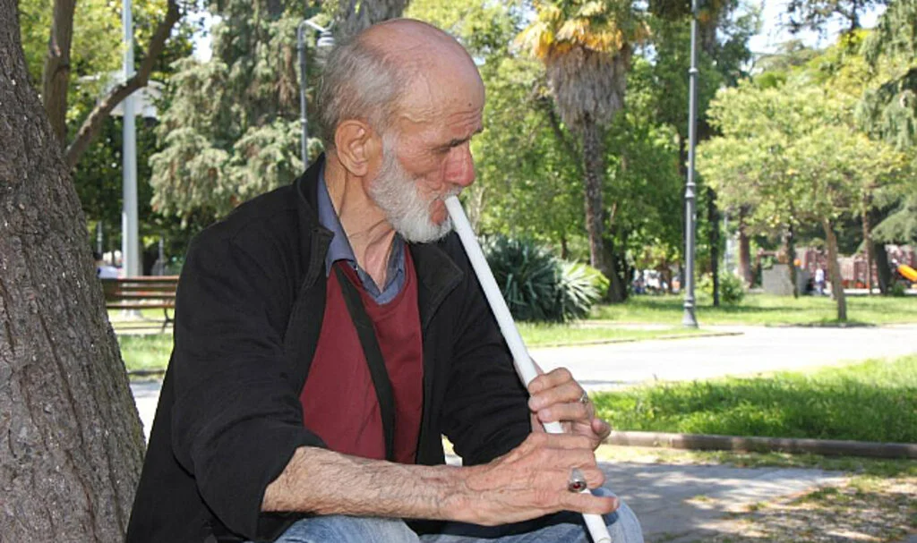 Kesik parmaklarıyla süpürge sapından yaptığı neyi çalıyor